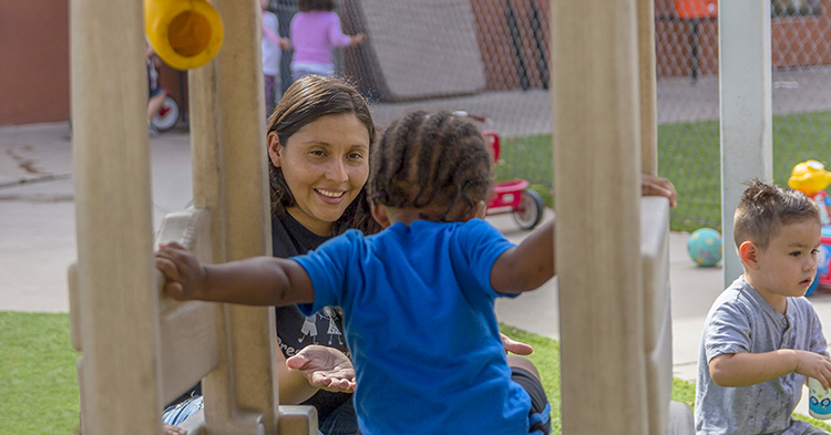 Child care worker with two toddler on playgrounds