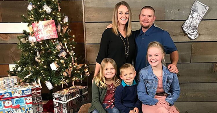 Family standing next to Christmas tree