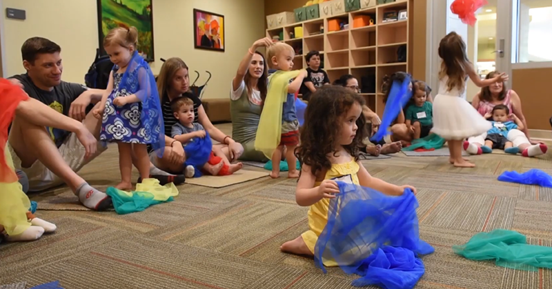 parents and young children play with scarves