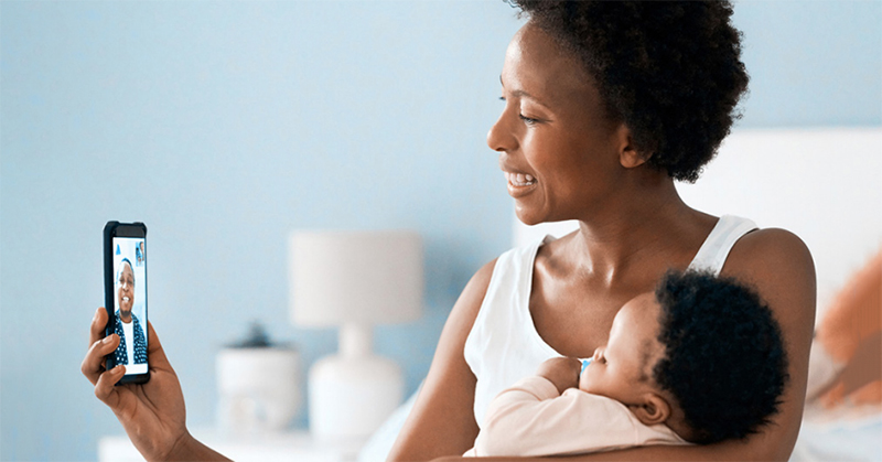 Mom holding baby while facetiming family member