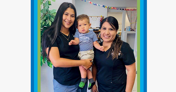 mom and her son standing with his teacher