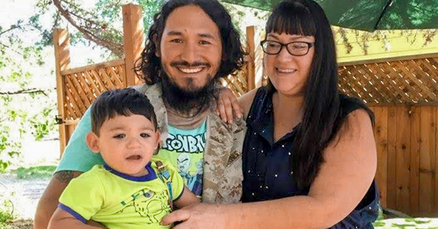 Dad with beard, mom in navy blue dress, toddler boy, son in yellow t-shirt