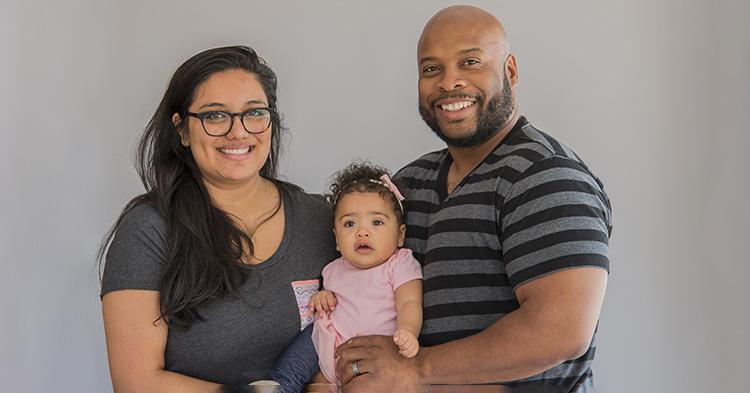 Photo of mom and dad holding baby girl